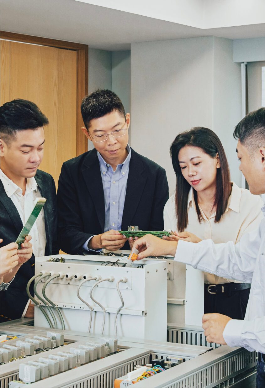 The Welltek team reviewing electronic control equipment